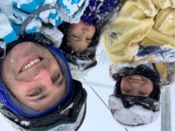 family of three on a chairlift in the snow