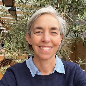 woman smiling outside in blue sweater