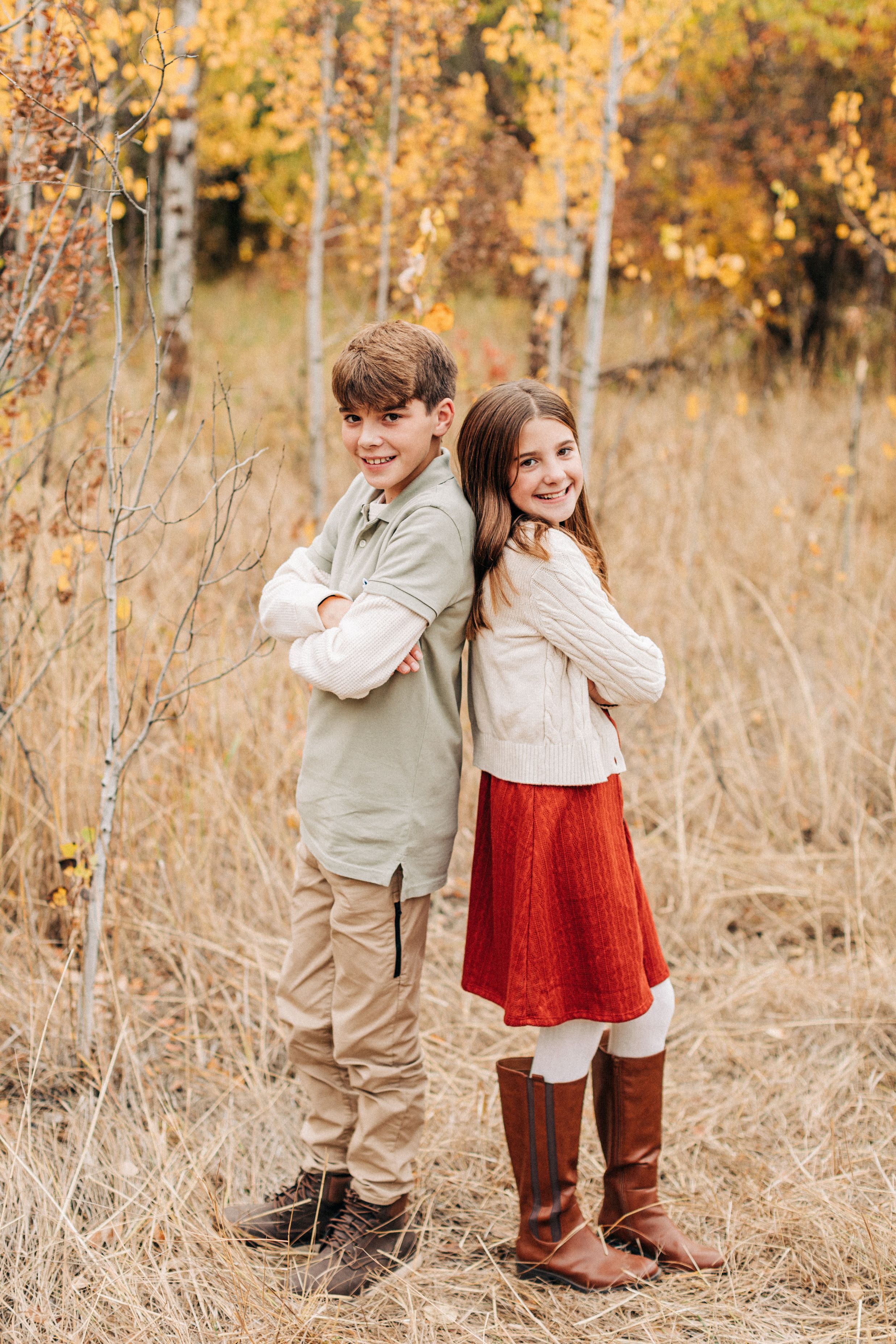 kids standing back to back in a wooded area