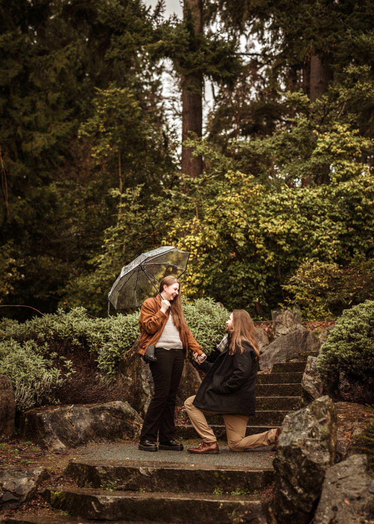 Colton Brodock proposing to Chey Malmin in a forested setting. 