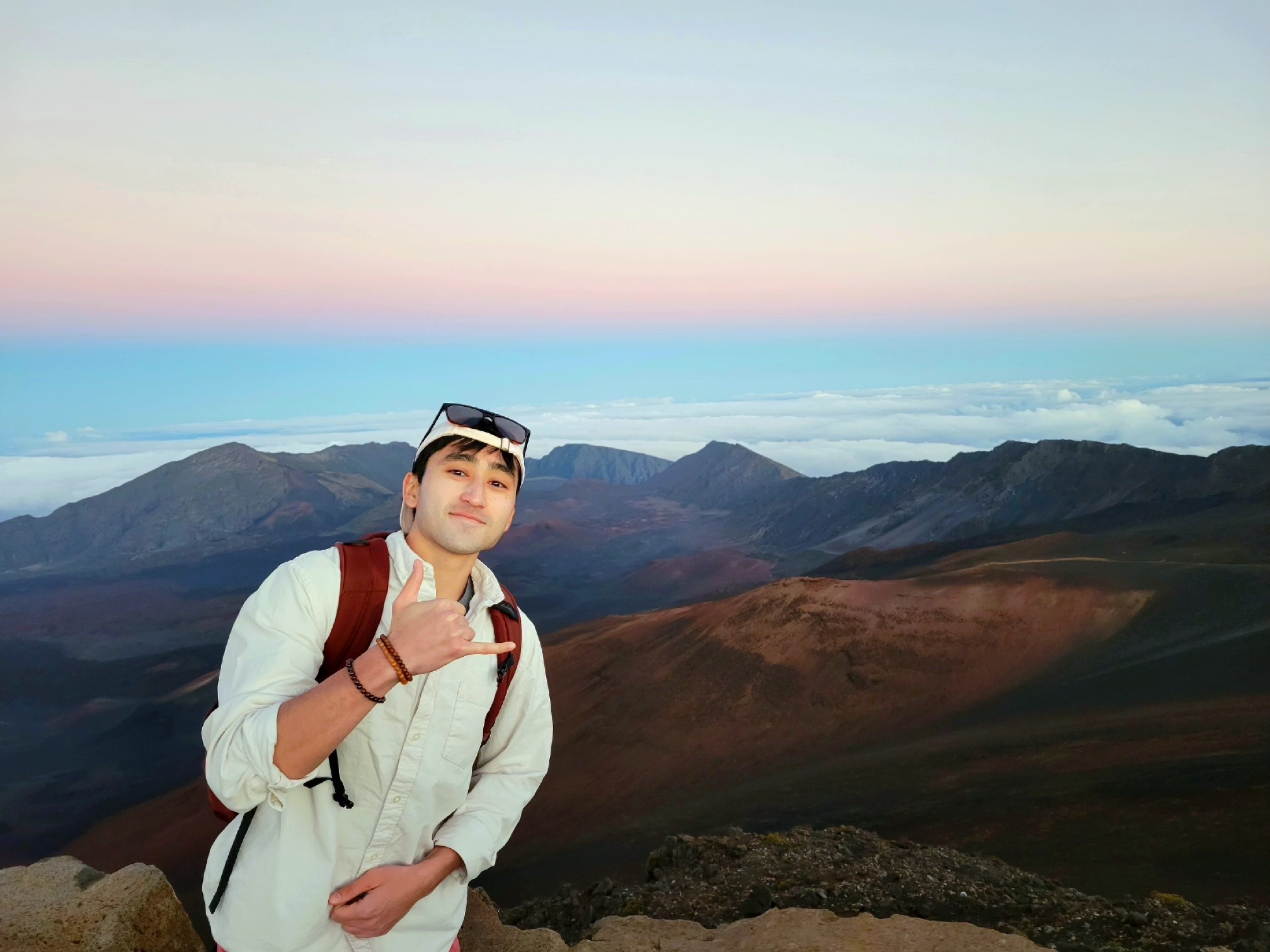 Arjun Kumar poses while making a "peace sign" in the mountains