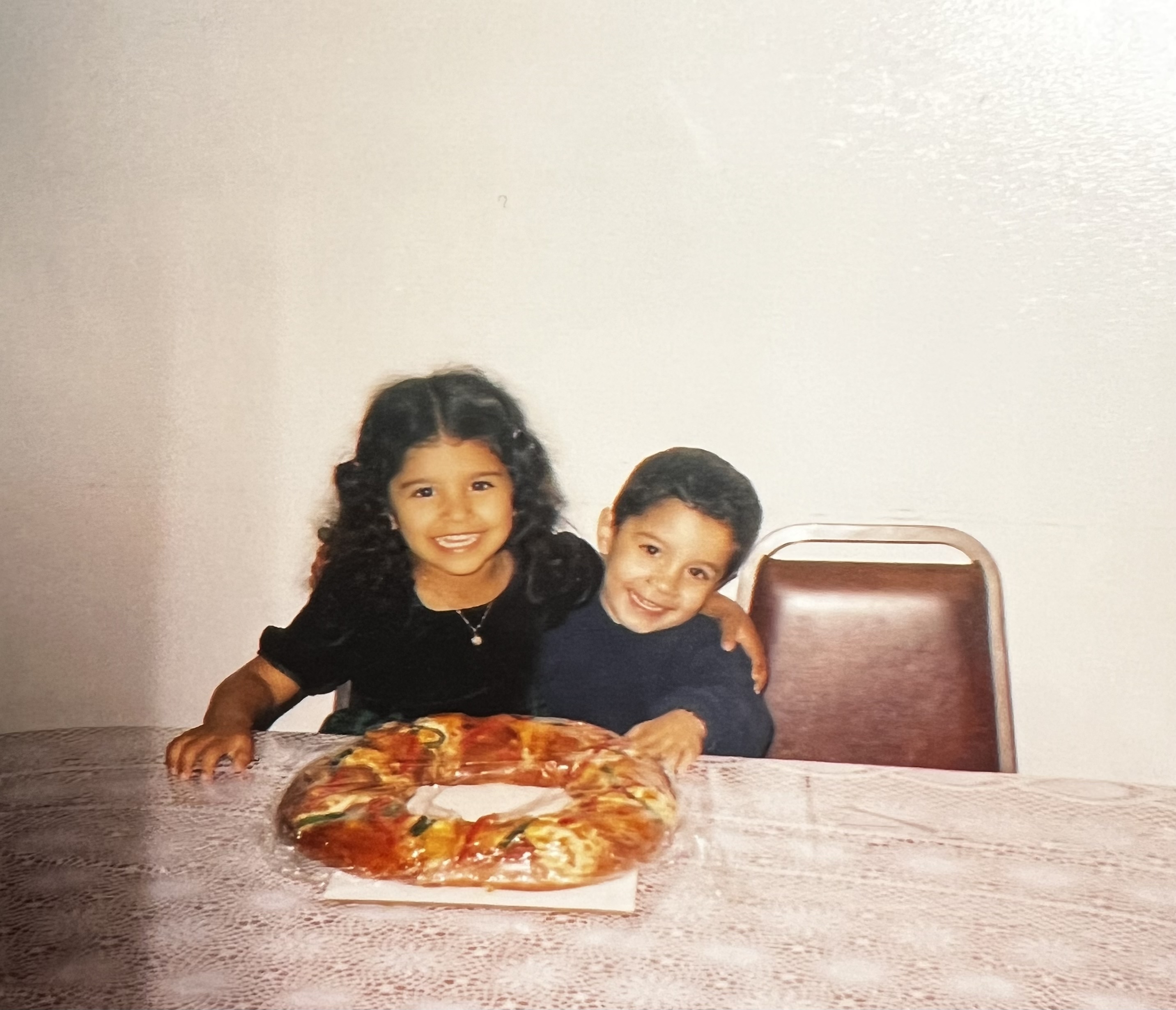 Two children pose together at a table