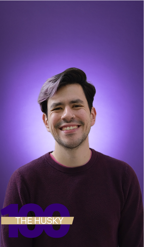 A headshot of Miguel Paredes in front of a purple background