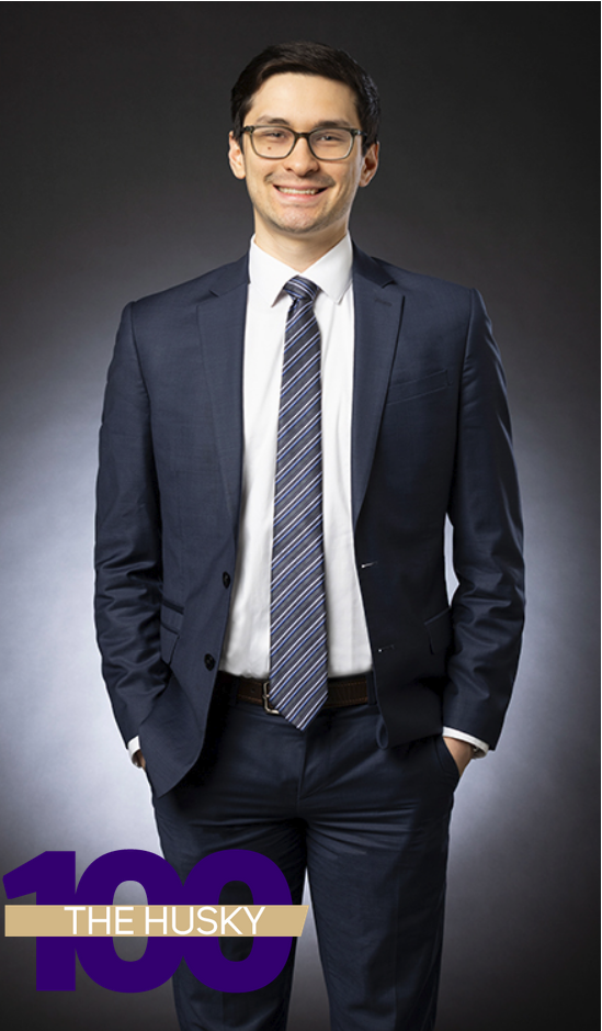 A full-body photo of Nevin C Kalaf in front of a grey background