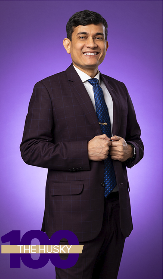 A full-body photo of Mohammad Gazi in front of a purple baxkground