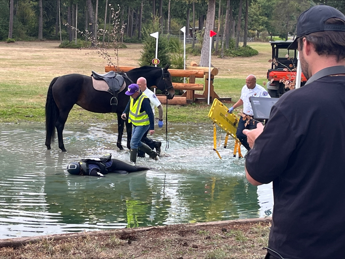 A still shot from the set of the equine safety film, featuring a rider who has fallen from a horse over water.