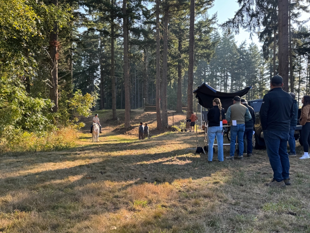 A scene from the filming process featuring a rider and horse in the woods