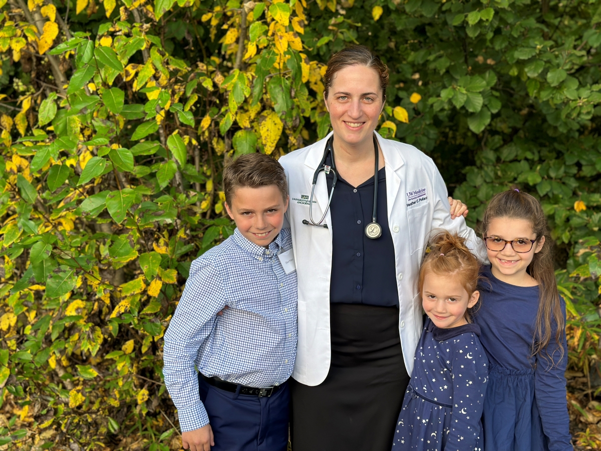 Heather Pollard poses in a white physician's coat alongside her three children