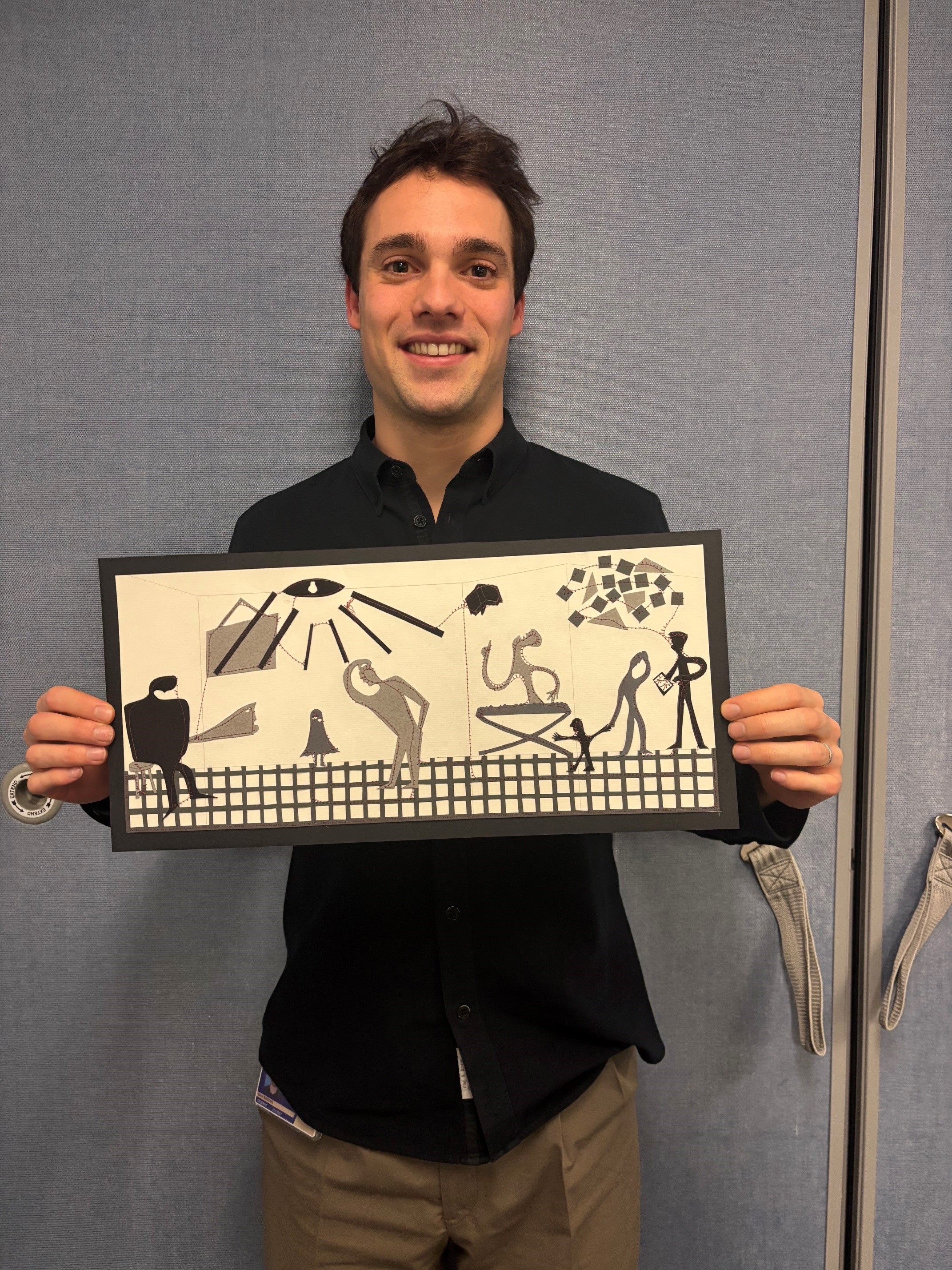 Dan Brooks poses with his project, A collage inspired by Picasso's Guernica set in an emergency department