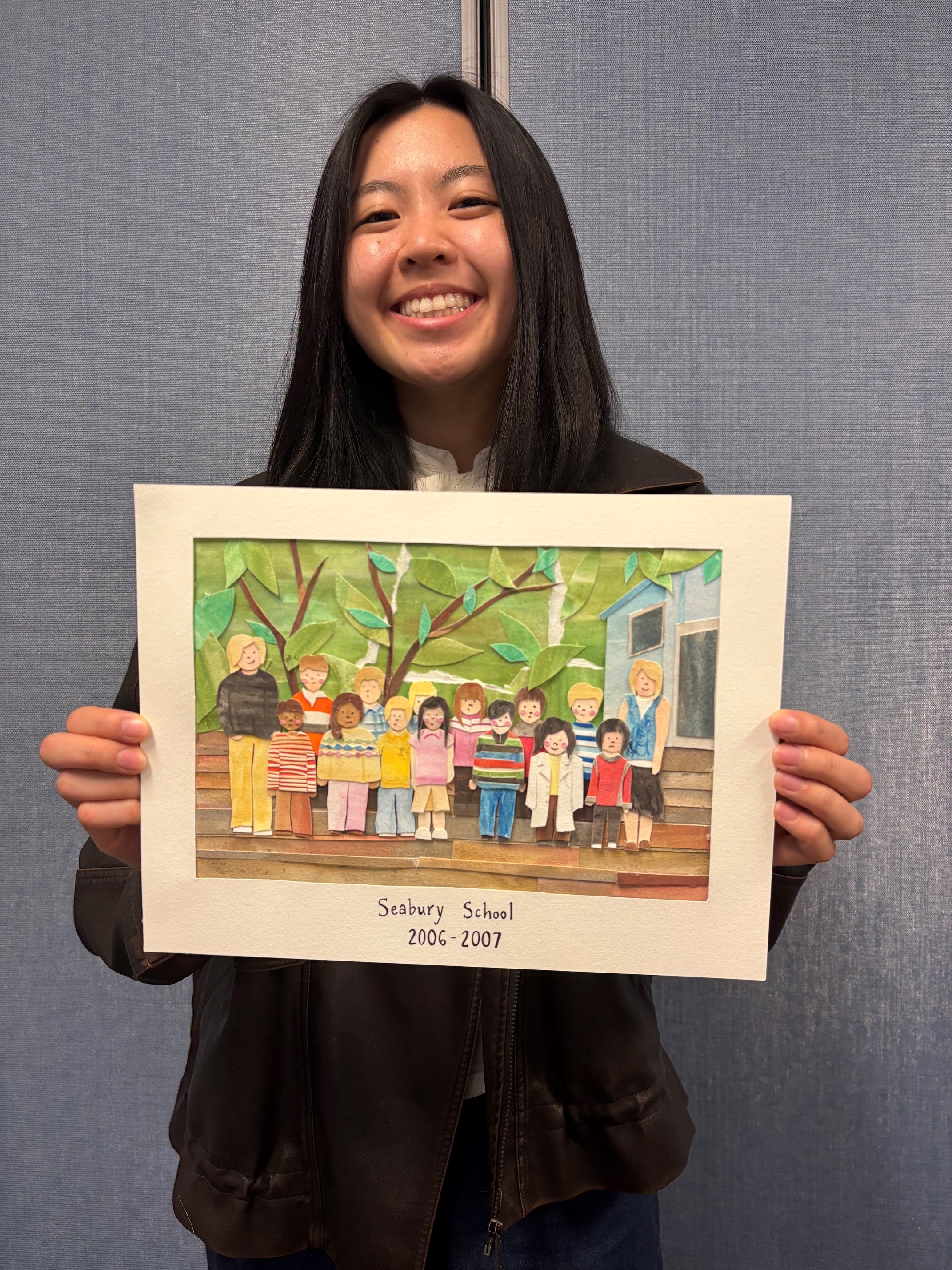 Gillian Soo poses with her project: a collage recreation of a childhood class photo featuring a young Soo in an oversize lab coat