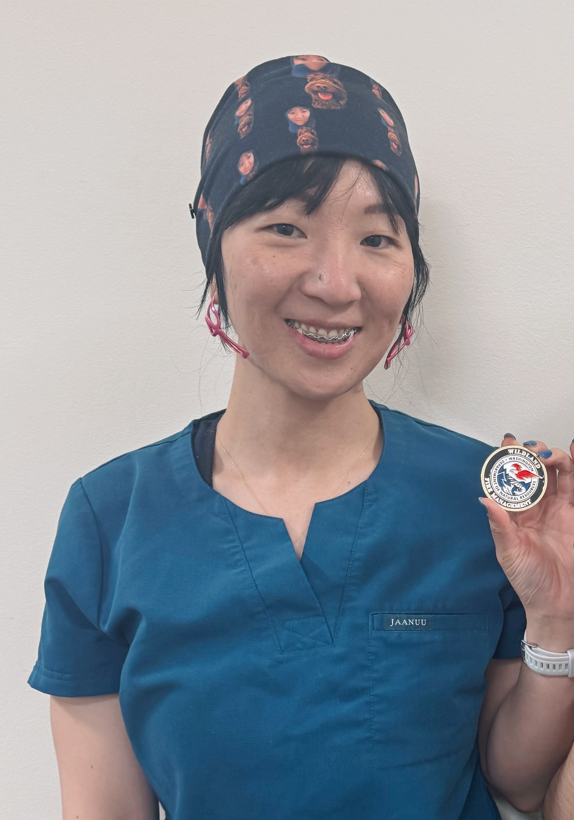 Dr. Zha holds up a challenge coin gifted to her by the fire fighters