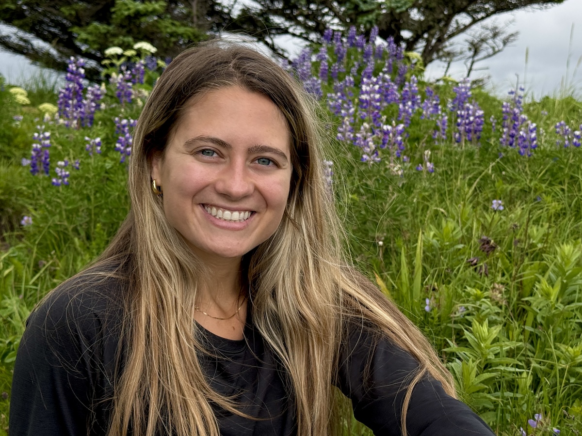 A backdrop of purple flowers and a smiling Mauri Butzke. 