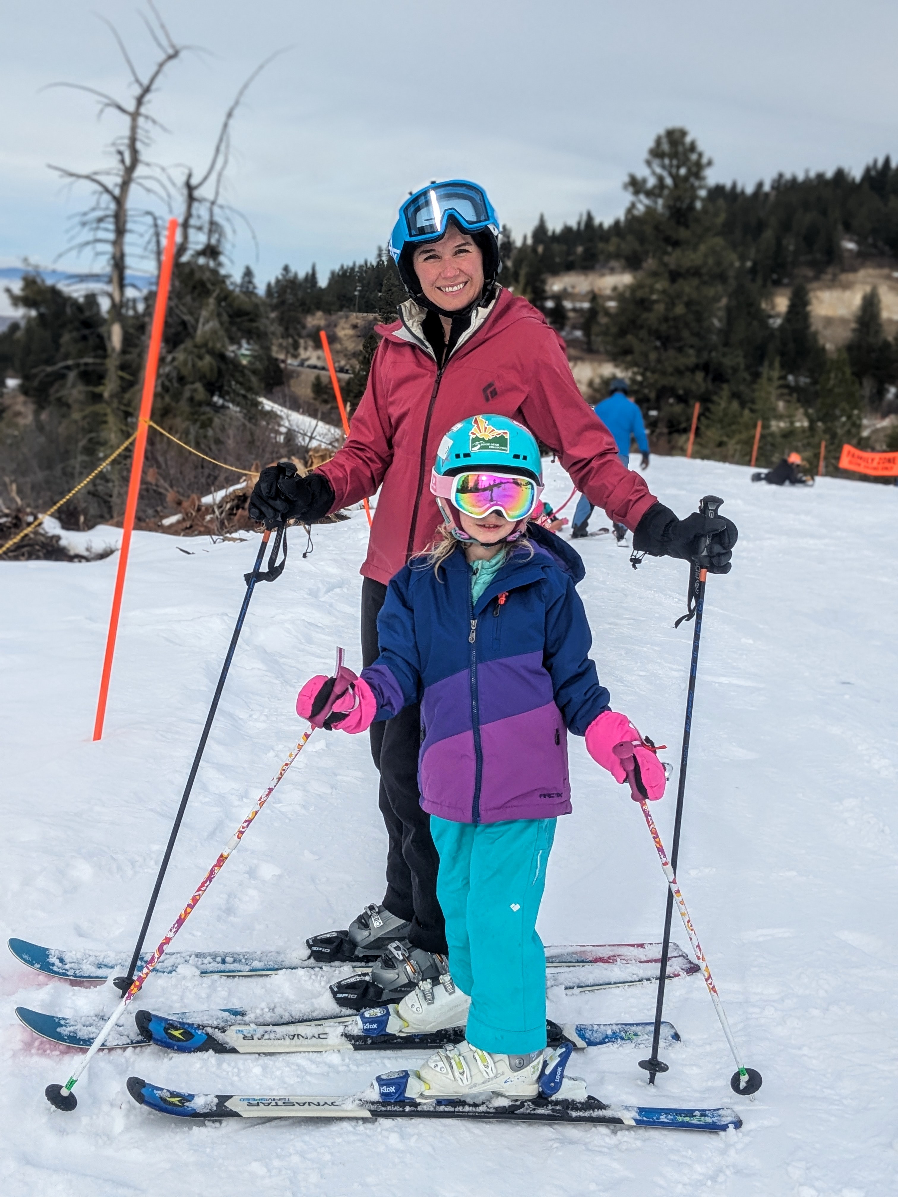 Dr. Kuntz and her daughter pose in skis in a snowy landscape