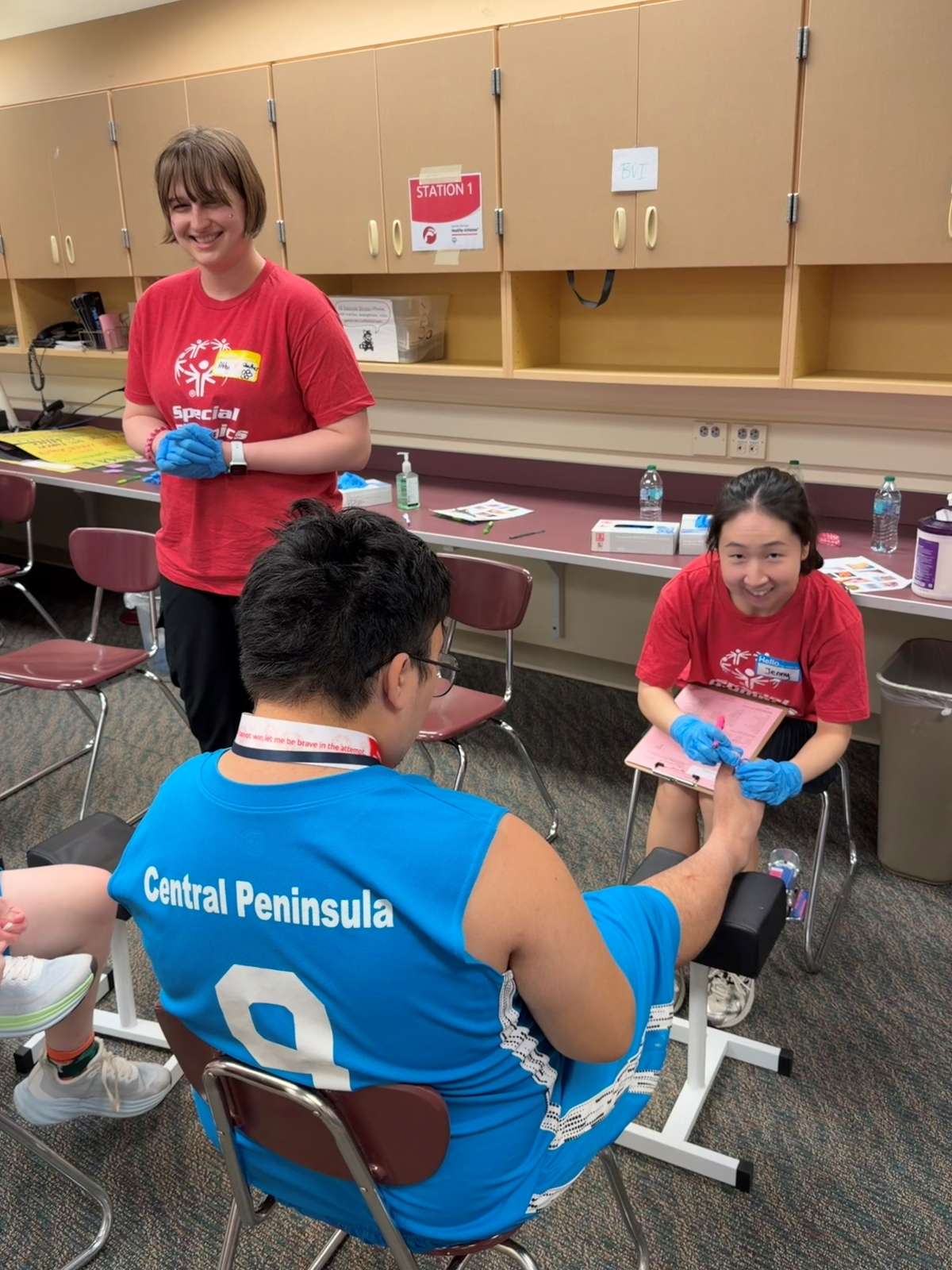 A volunteer assesses a Special Olympics' athlete's foot. 