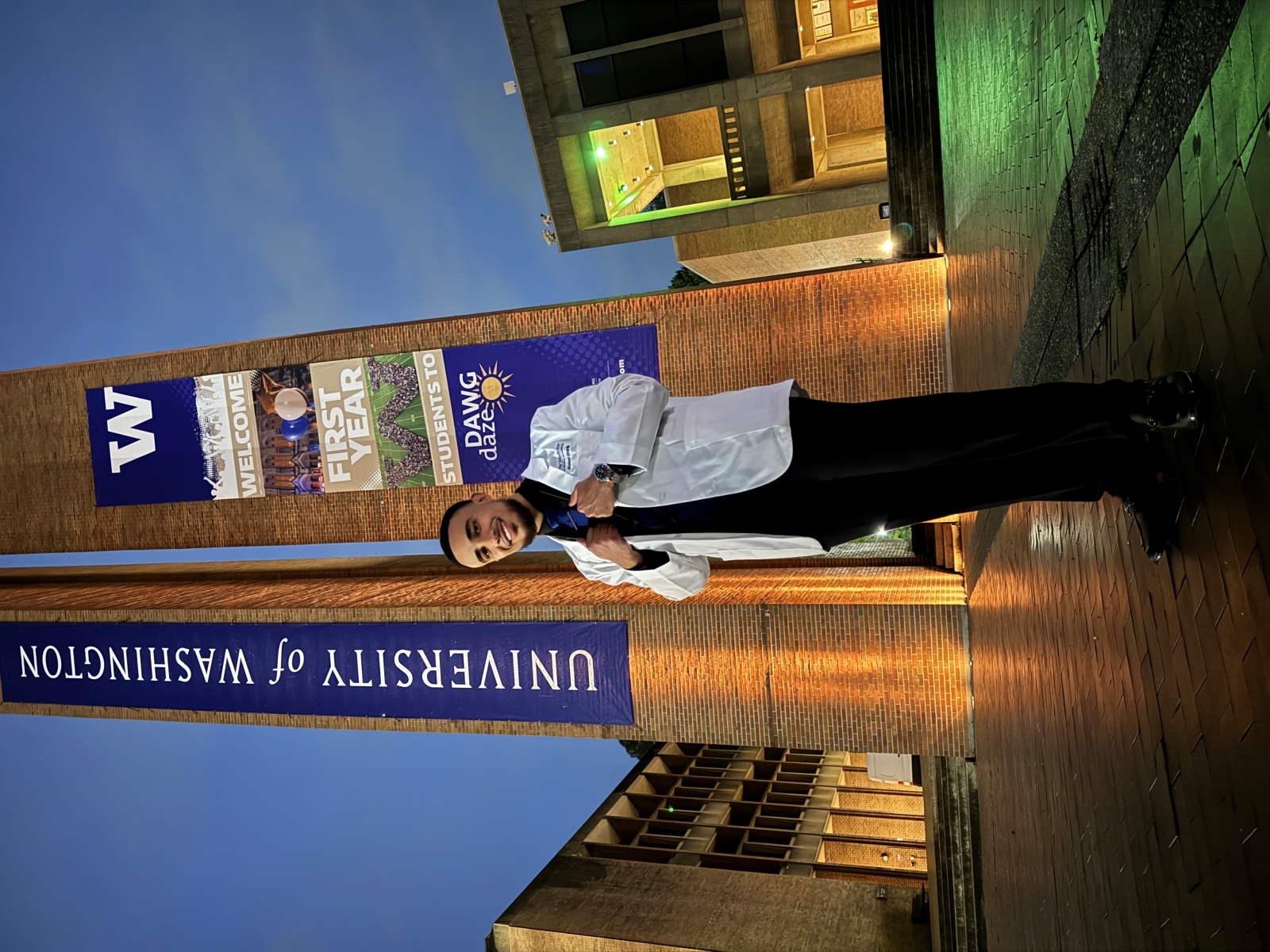 Waleed Gharib poses on the UW campus in his white coat